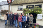 Mel Stride MP outside the Drewe Arms Pub with staff and customers.
